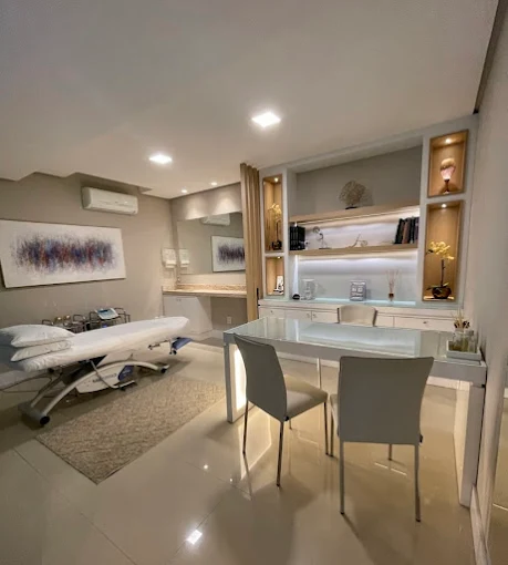 Sala de atendimento da clínica com mesa e maca